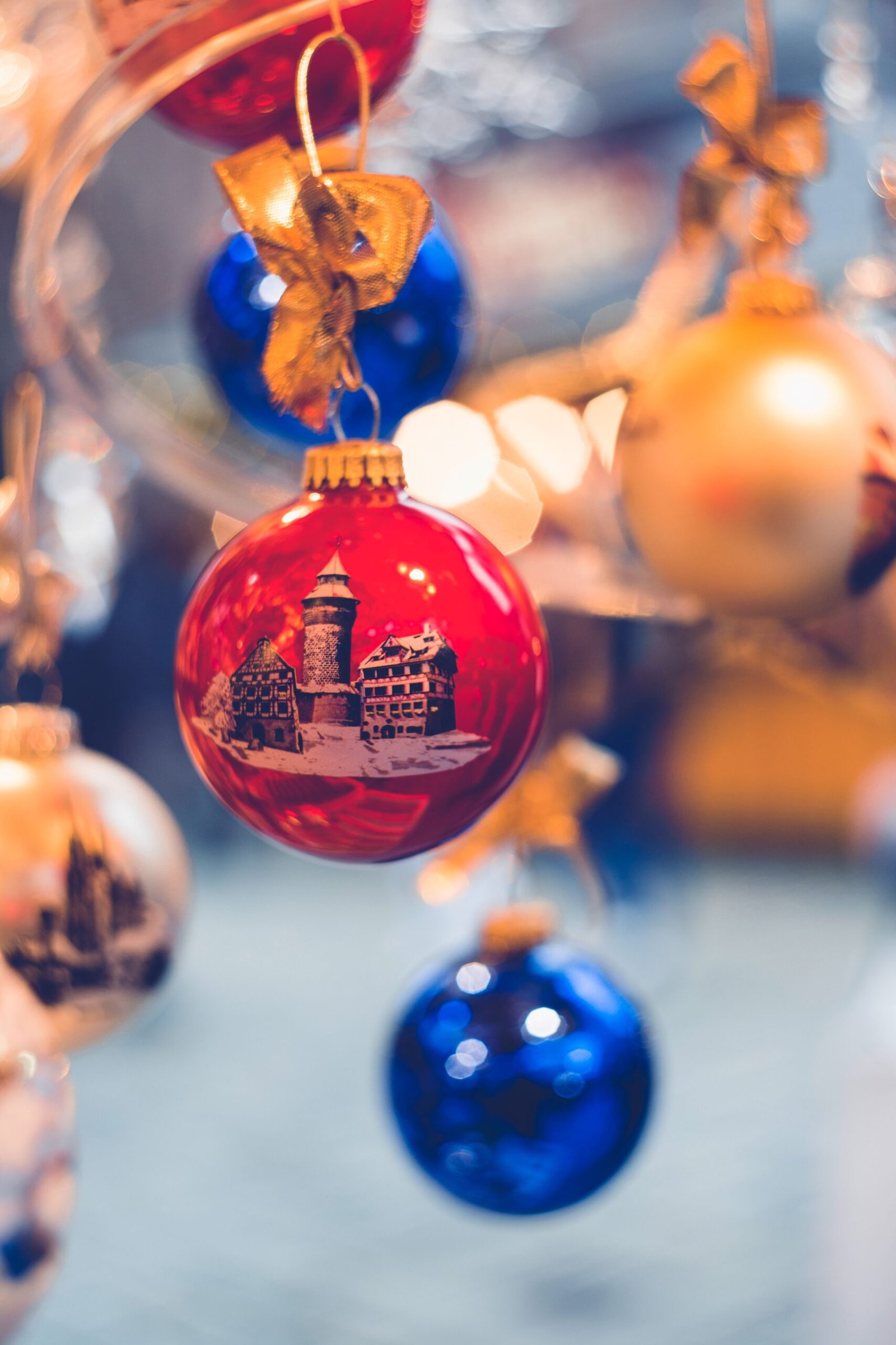 Red and gold Christmas baubles arranged on a white surface