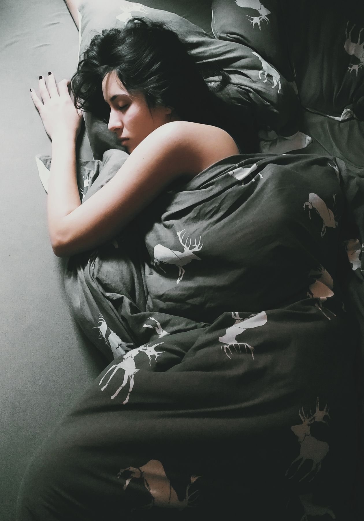 Person resting in bed under a warm blanket on a cold winter morning