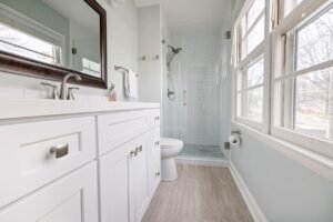 Bright modern bathroom with a glass shower, white vanity and large mirror, suited to a wet room shower tray