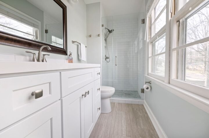 Bright modern bathroom with a glass shower, white vanity and large mirror, suited to a wet room shower tray